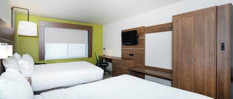 A hotel room with two beds, a desk, a television, and a wardrobe.
