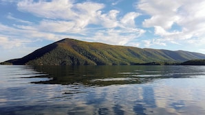Una montaña con un lago en primer plano y un cielo despejado.