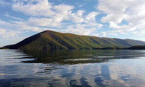 Une montagne avec un lac au premier plan et un ciel dégagé.