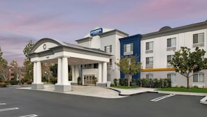A hotel with a covered entrance, a blue building, and a parking lot. - City Express By Marriott Rancho Cucamonga (Rancho Cucamonga)