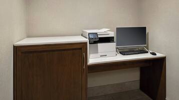 A corner office with a desk, a printer, a computer, and a cabinet.