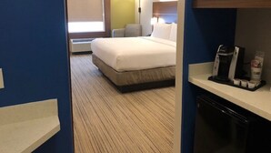 A hotel room with a bed, a bedside lamp, a microwave, and a coffee maker on a counter. - Holiday Inn Express & Suites Rio Grand by IHG (Rio Grande City)