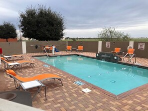 Une piscine extérieure avec des chaises longues et un toboggan.