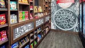 Un pasillo con diversos snacks envasados y un mural que dice "TREATES".