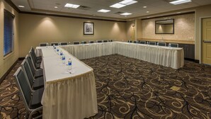 A conference room with a long table, chairs, and water bottles.