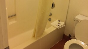 Un baño con bañera, inodoro y cortina de ducha.