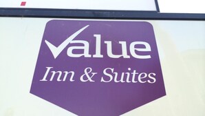 Un letrero para Value Inn & Suites con un logotipo púrpura.