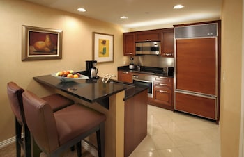 A lobby with a reception desk, a large painting, and seating arrangements including a sofa and chairs. at The Signature at MGM Grand (All Suites)