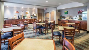 A hotel dining area with multiple tables and chairs, a coffee station, and a buffet. - Quality Inn & Suites Sequim at Olympic National Park (Sequim)