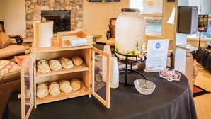 A buffet setup with a large water dispenser, a wooden bread display, and a sign indicating a 10% discount. - Quality Inn & Suites Sequim at Olympic National Park (Sequim)
