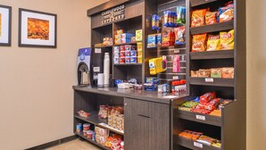 A self-service beverage station with a coffee machine, a water dispenser, and a variety of snacks and beverages. - Candlewood Suites Beaumont by IHG (Beaumont)