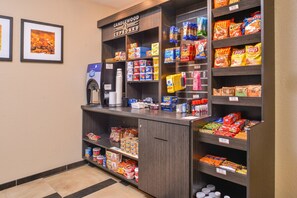 A self-service beverage station with a coffee machine, a water dispenser, and a variety of snacks and beverages. - Candlewood Suites Beaumont by IHG (Beaumont)