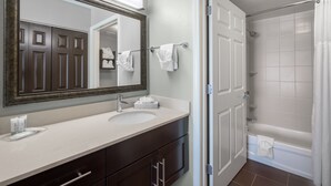 A bathroom with a large mirror, a sink, a bathtub, and a shower. - Staybridge Suites Wilmington-Newark by IHG (Newark)