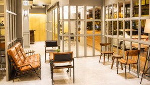Een modern interieur met zithoekjes en grote ramen.