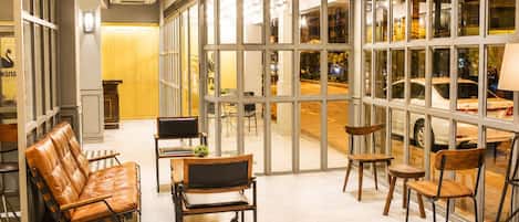 Un intérieur moderne avec des espaces aménagés pour s’asseoir et de grandes fenêtres.
