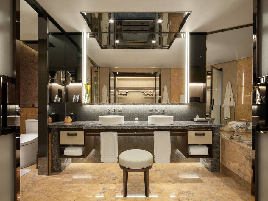 A modern bathroom with two sinks, a vanity, and a large mirror.