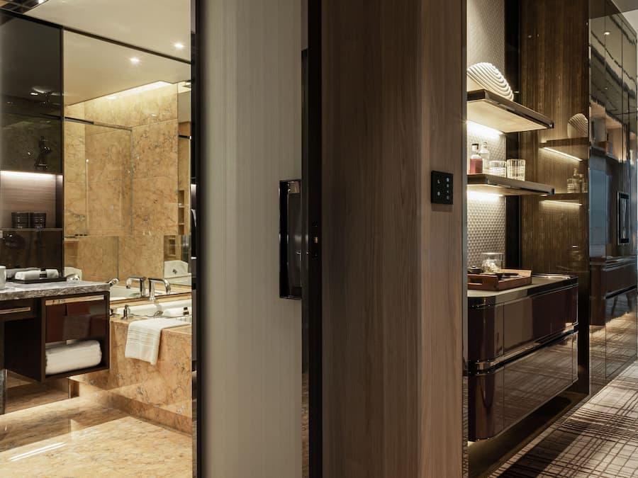 A modern bathroom with a marble floor, a large mirror, and a wooden vanity.