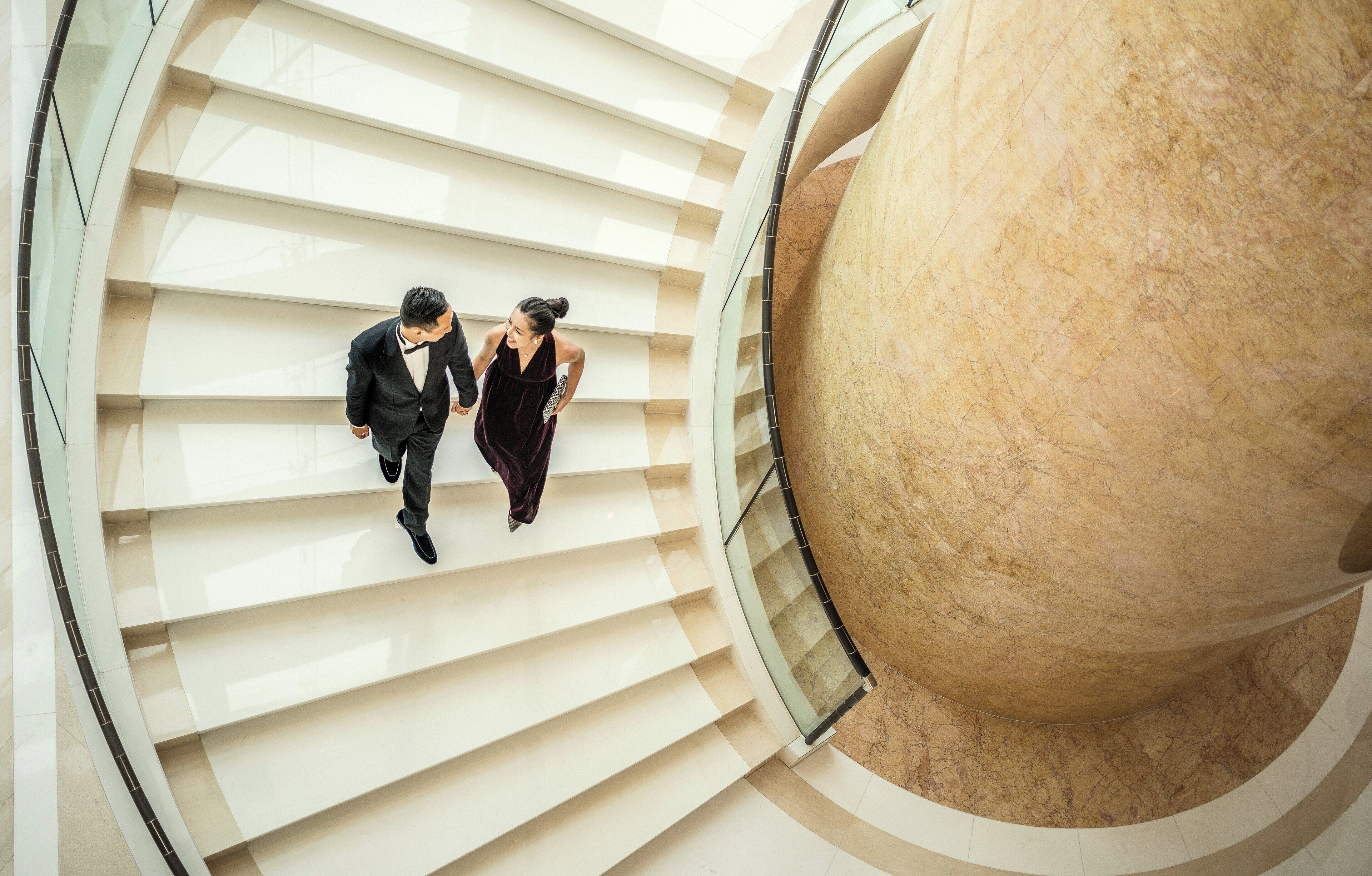 Un interior moderno con una escalera curva y una gran estructura de mármol.