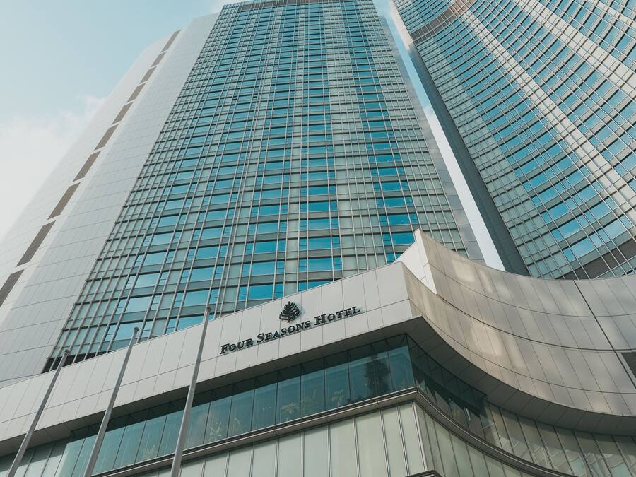 Een modern hotelgebouw met een glazen gevel en een gebogen entree.