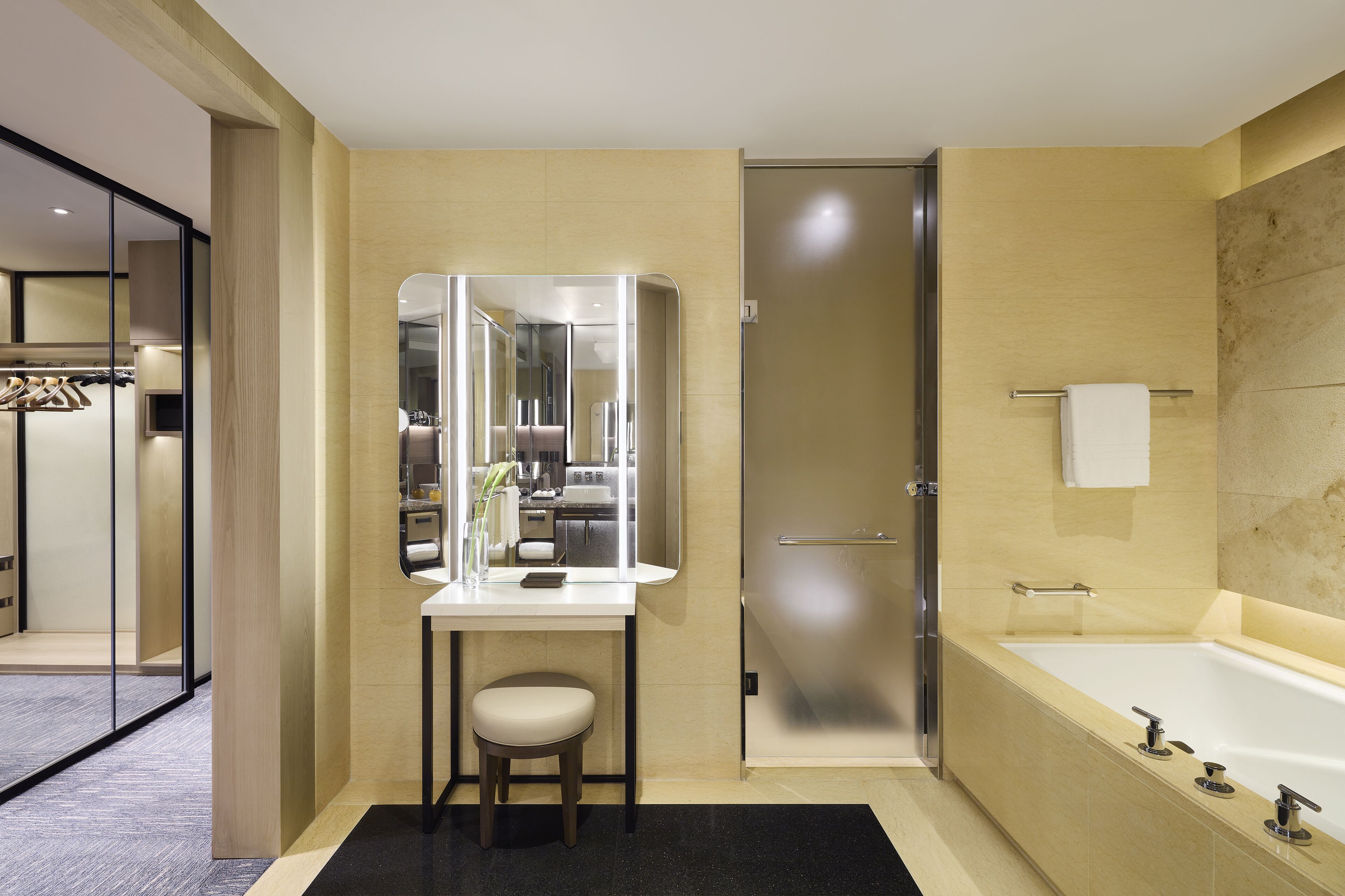 A modern bathroom with a large mirror, a sink, a toilet, and a bathtub.