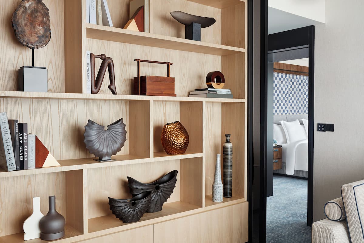 Een houten plankenwand met decoratieve objecten en boeken.