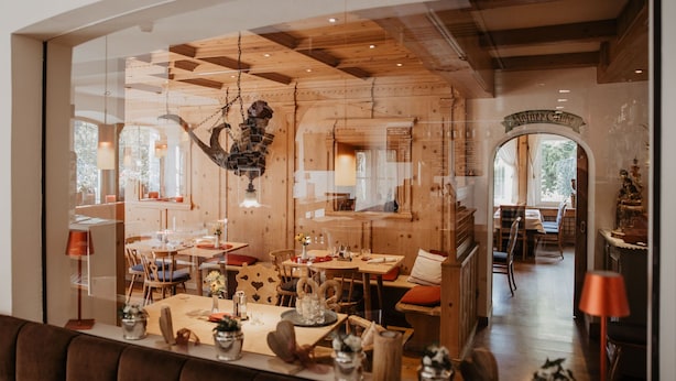 Ein Restaurant mit Holzvertäfelungen, gedeckten Tischen und einer hängenden Dekoration.
