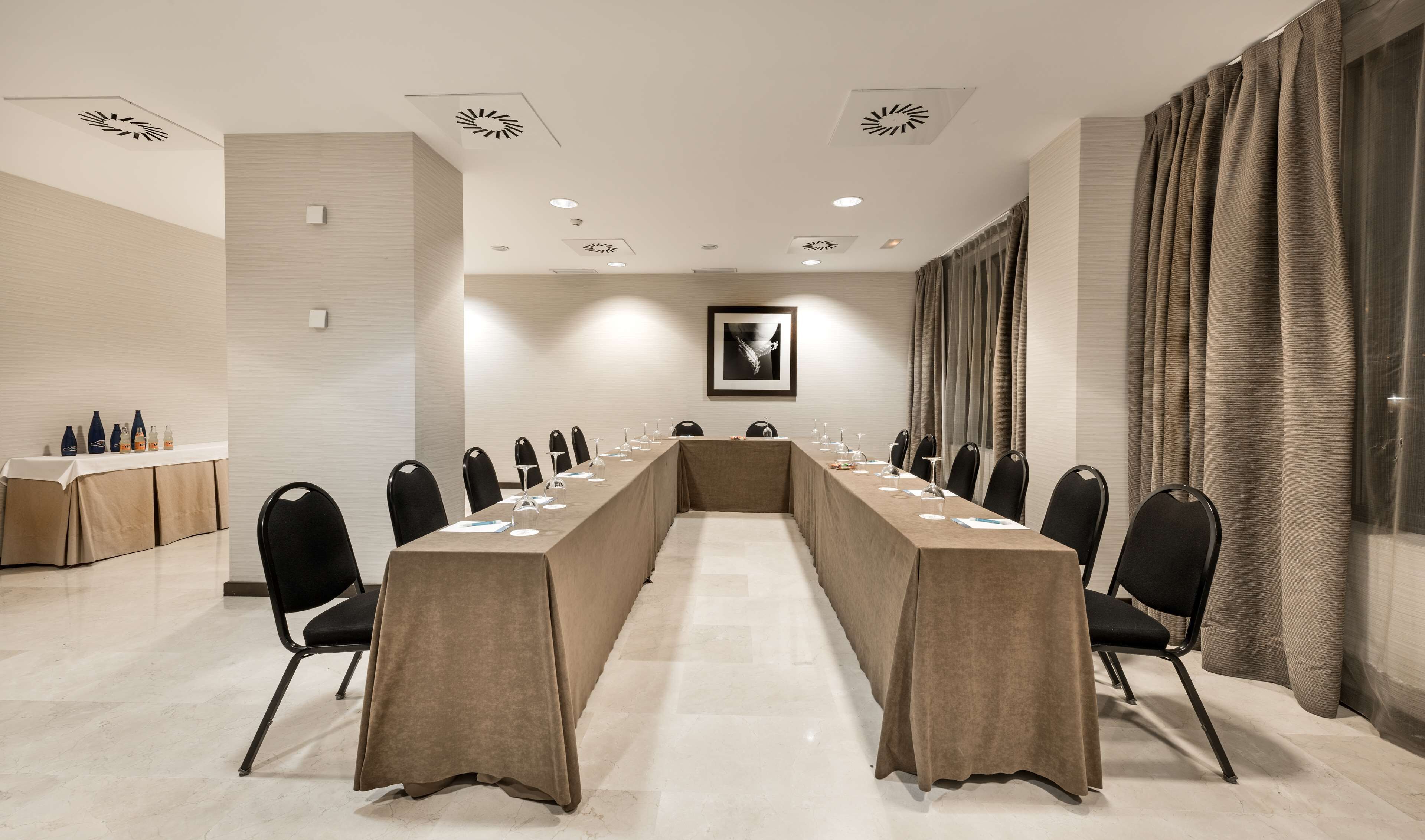 A conference room with a long table, chairs, and a whiteboard.