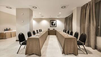 A conference room with a long table, chairs, and a whiteboard.
