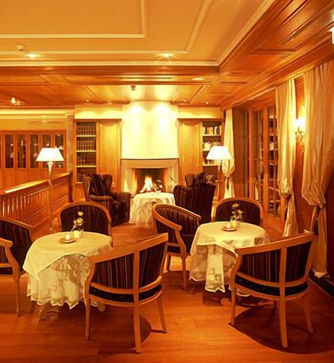 A warmly lit dining area with wooden furniture and a fireplace.