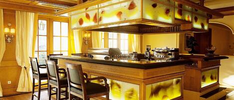 A spacious kitchen with a large island, wooden chairs, and a dining area with a table and chairs.