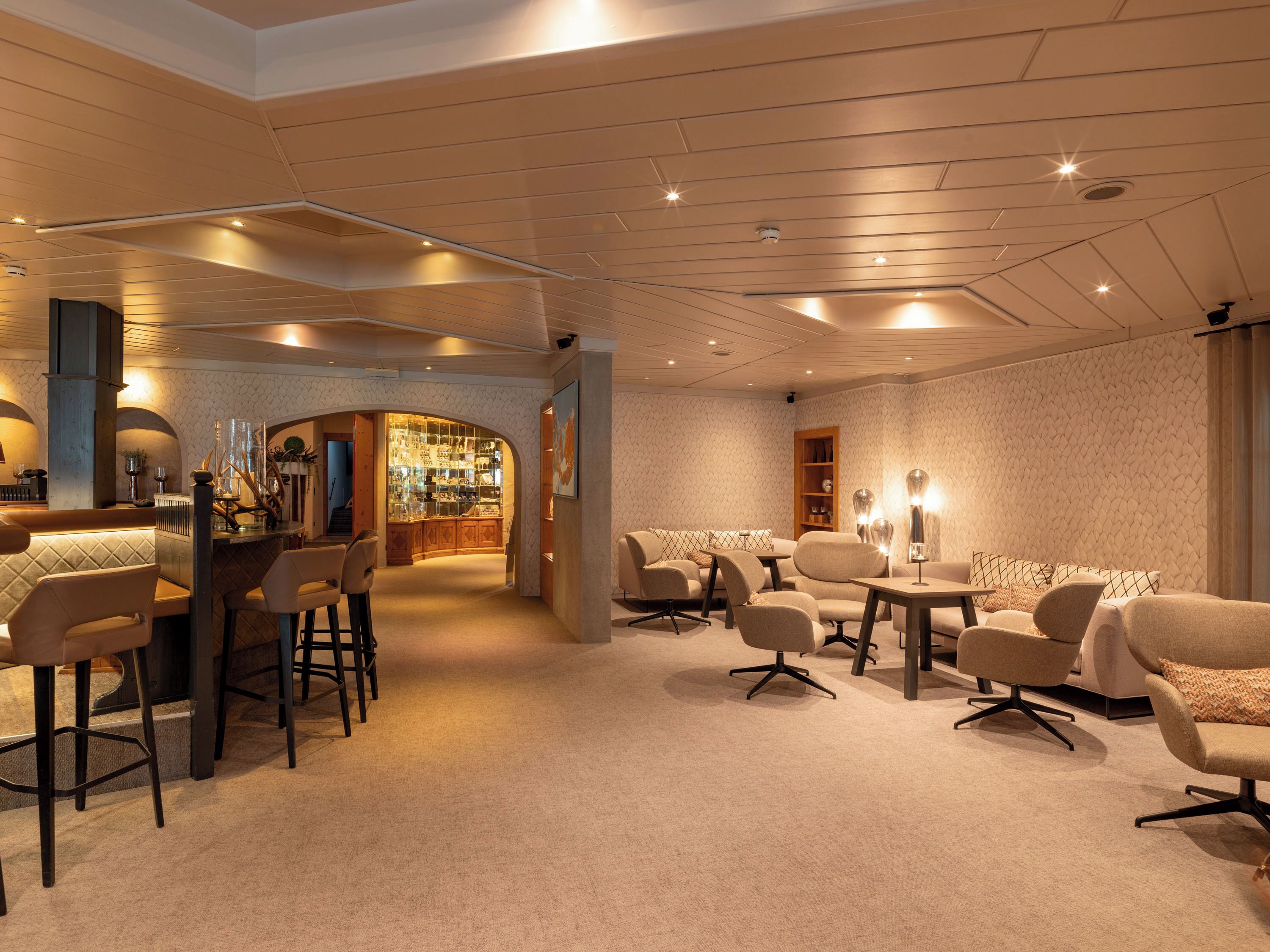 A modern interior with a bar area, seating, and a display case.