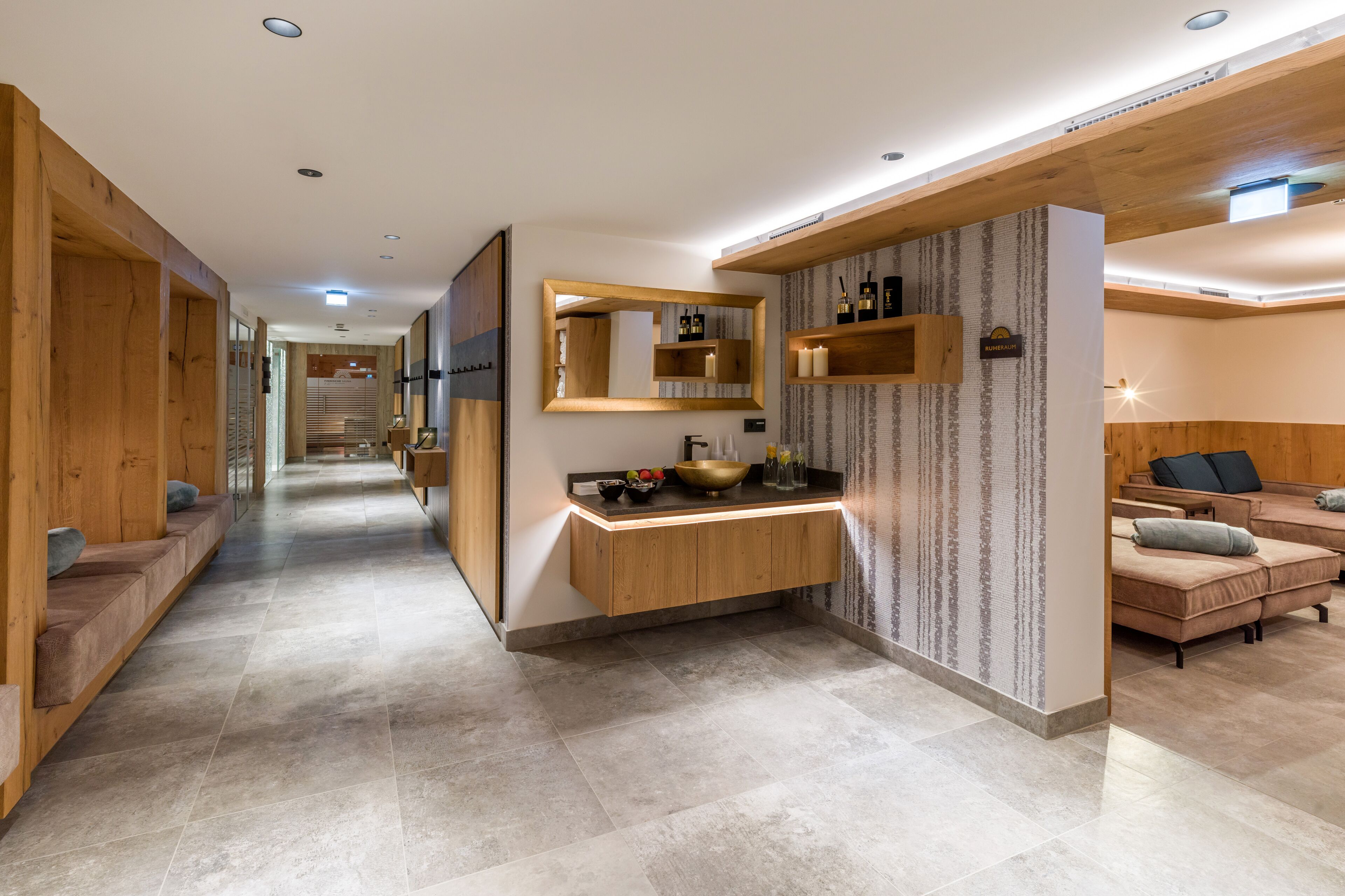 Un baño moderno con un tocador de madera, un espejo grande y un estante en la pared con artículos de aseo.