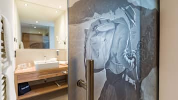Ein Badezimmer mit großem Spiegel, Waschbecken und Handtuchhalter.
