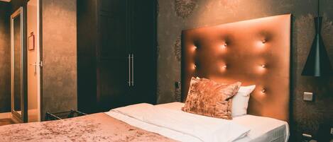 Une chambre à coucher avec un grand lit, une armoire en bois foncé et un mur décoratif.