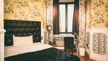 A hotel room with a bed, a desk, and a chair.