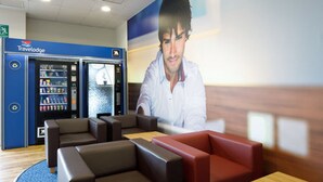 Een Travelodge lobby met zitgedeeltes, een automaat en een balie.