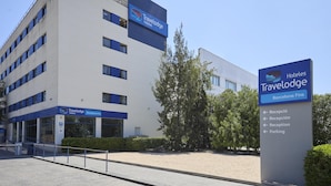 Een Travelodge hotelgebouw met een bord waarop receptie en parkeerplaats aangegeven staan.