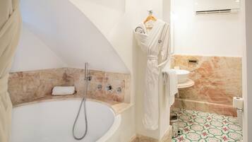 A modern bathroom with a freestanding bathtub, a towel rack, and a toilet.