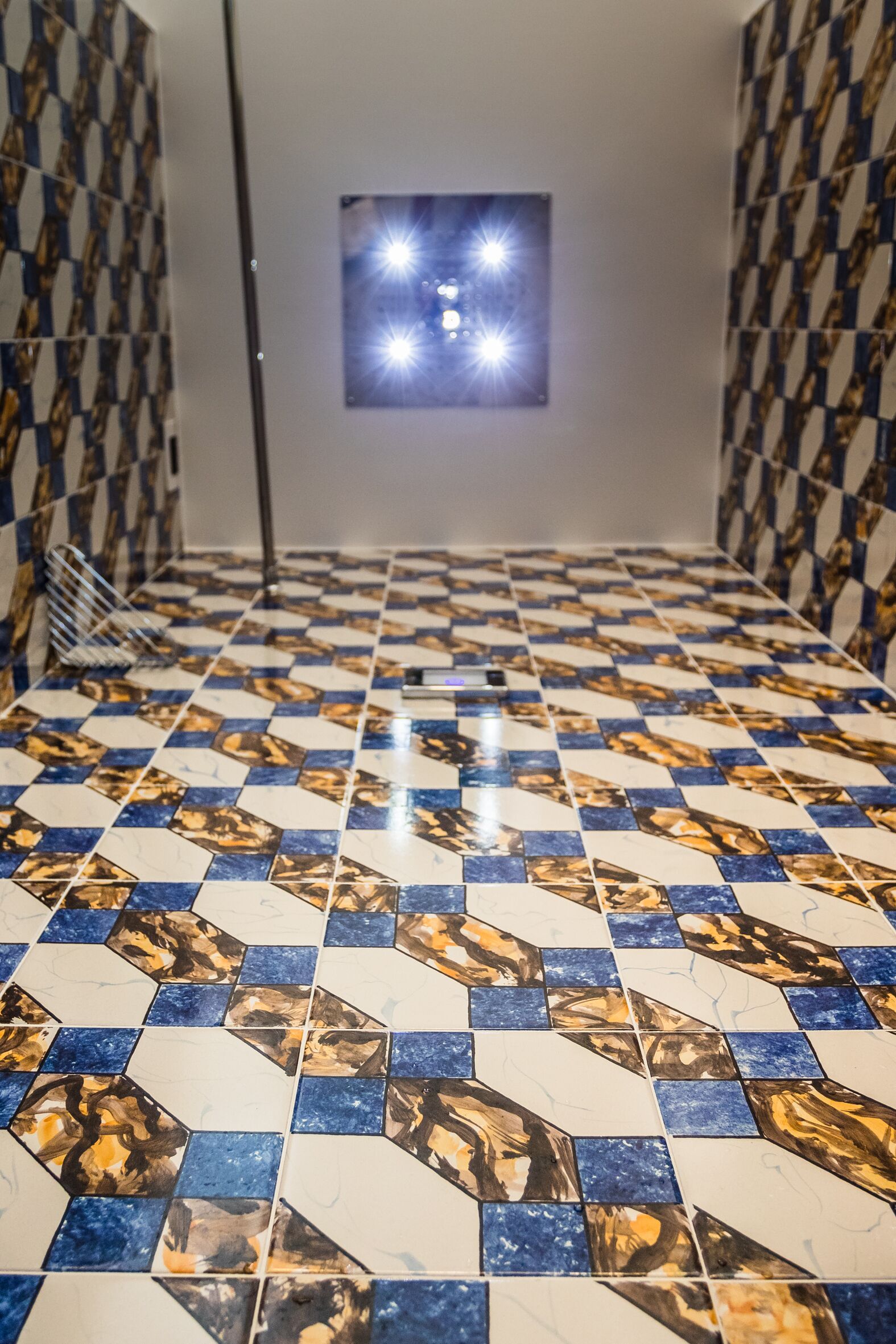 A tiled hallway with a checkered pattern and a small window with bright lights.
