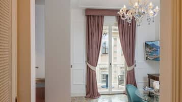 Una habitación con una mesa de cristal, un candelabro y vistas al mar.