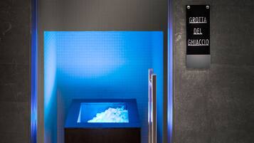 A bathroom with a blue-lit sink and a sign reading "Grotia del Ghiaccio".