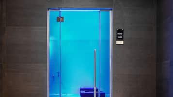 Un ascensor modern amb interior il·luminat de blau, porta de vidre transparent i senyalitzador del nivell de l'pis.