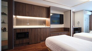 A modern hotel room with a wooden vanity, a flat-screen TV, a bed, and a desk area. - Western Coop Residence Dongdaemun (Seoul)