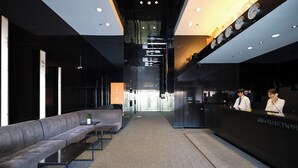 A modern hotel lobby with a reception desk, a seating area, and a conference sign. - Western Coop Residence Dongdaemun (Seoul)