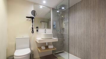 Ein modernes Badezimmer mit Toilette, Waschbecken und einer Duschkabine aus Glas.