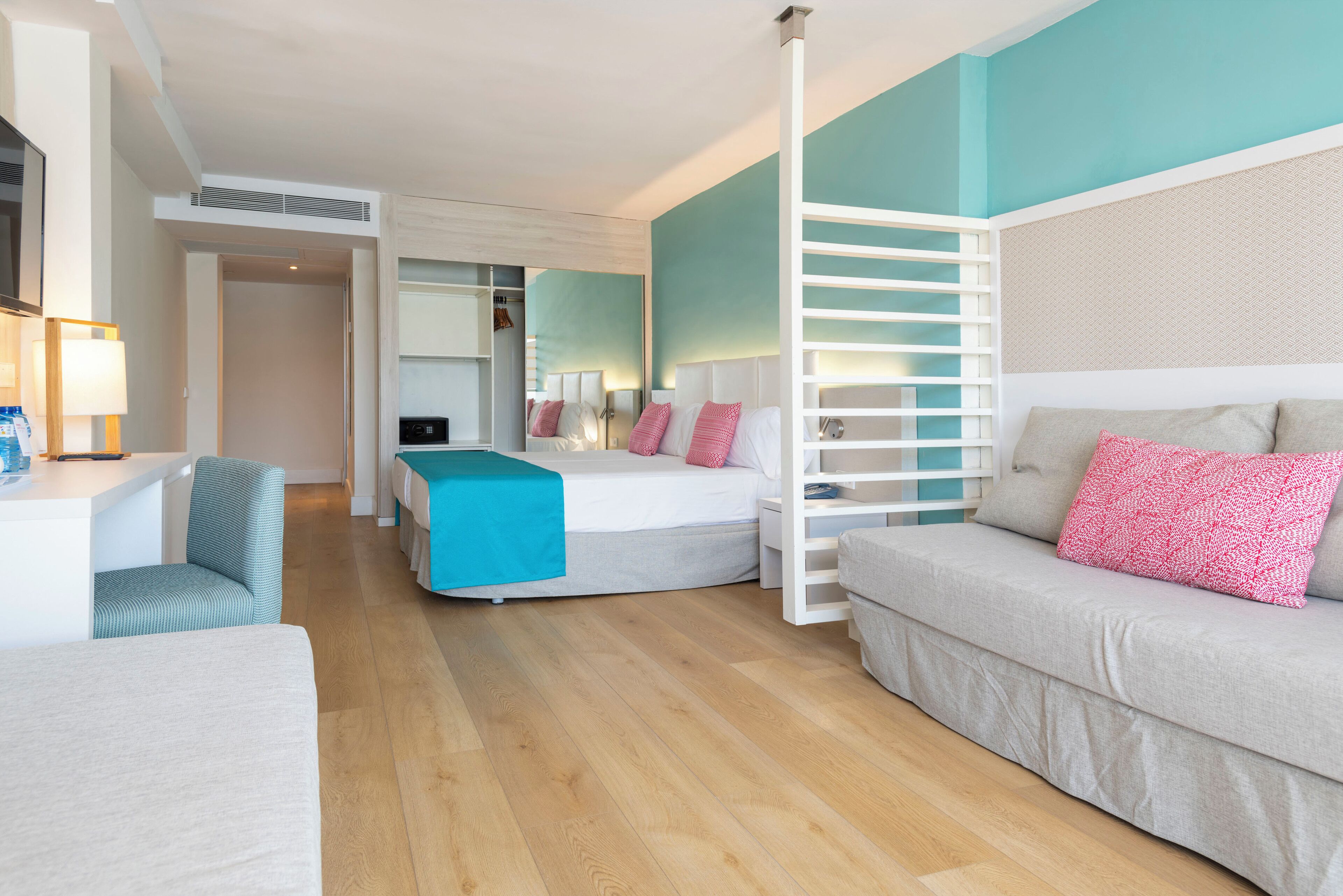 Una habitación de hotel moderna con cama, sofá, escritorio y silla.