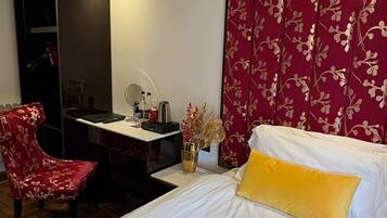 Una habitación de hotel con una cama, un escritorio, una silla y un armario.