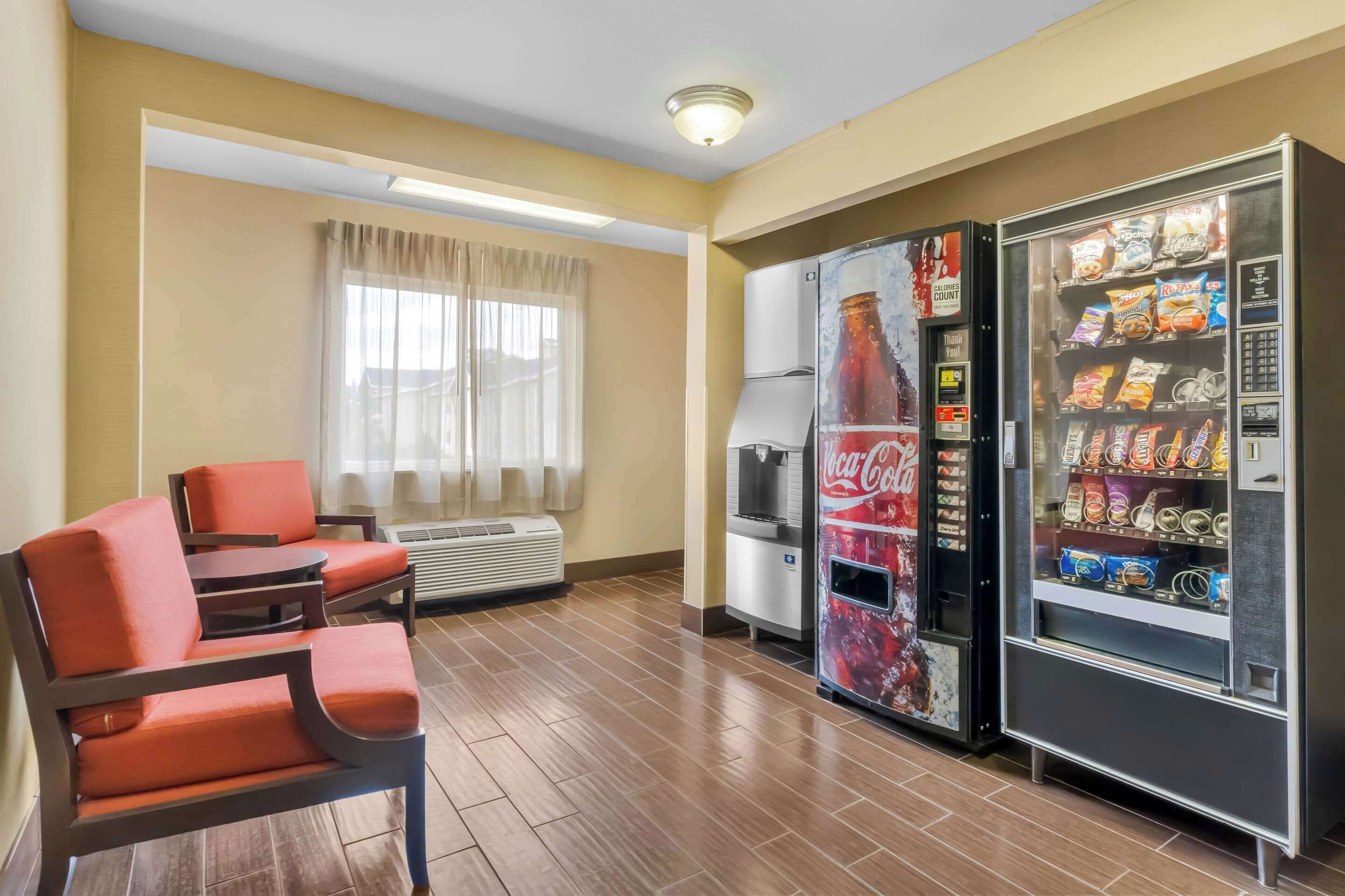 Una camera d'albergo con area soggiorno, frigorifero e distributore automatico.