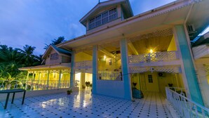 A two-story building with a balcony, a staircase, and a tiled floor. - Palm Beach Hotel (Praslin Island)