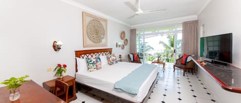 Una habitación de hotel con cama, televisión, mesa de comedor y vistas al exterior.